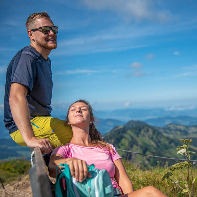 Wanderer genießen die Aussicht auf dem Hochgrat über Steibis und die Allgäuer Berge