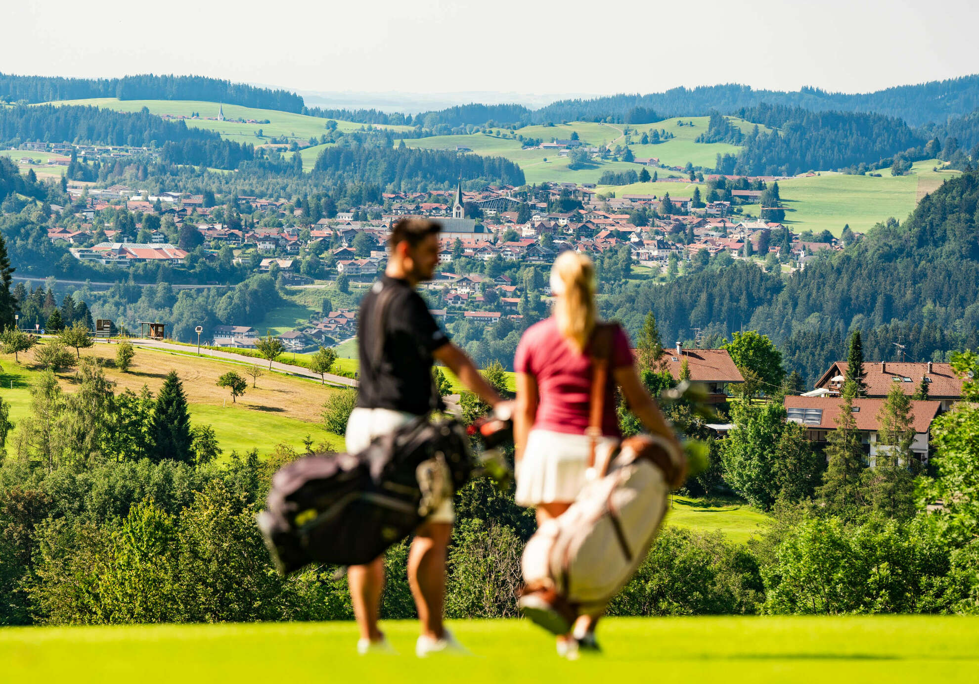 Golfer blicken vom Golfplatz Steibis auf den Ort Oberstaufen