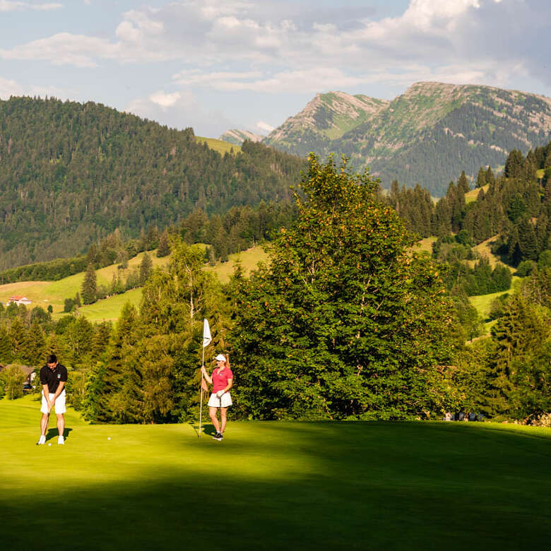 Golfer auf dem Gofplatz Steibis mit Sicht auf den Hochgrat.