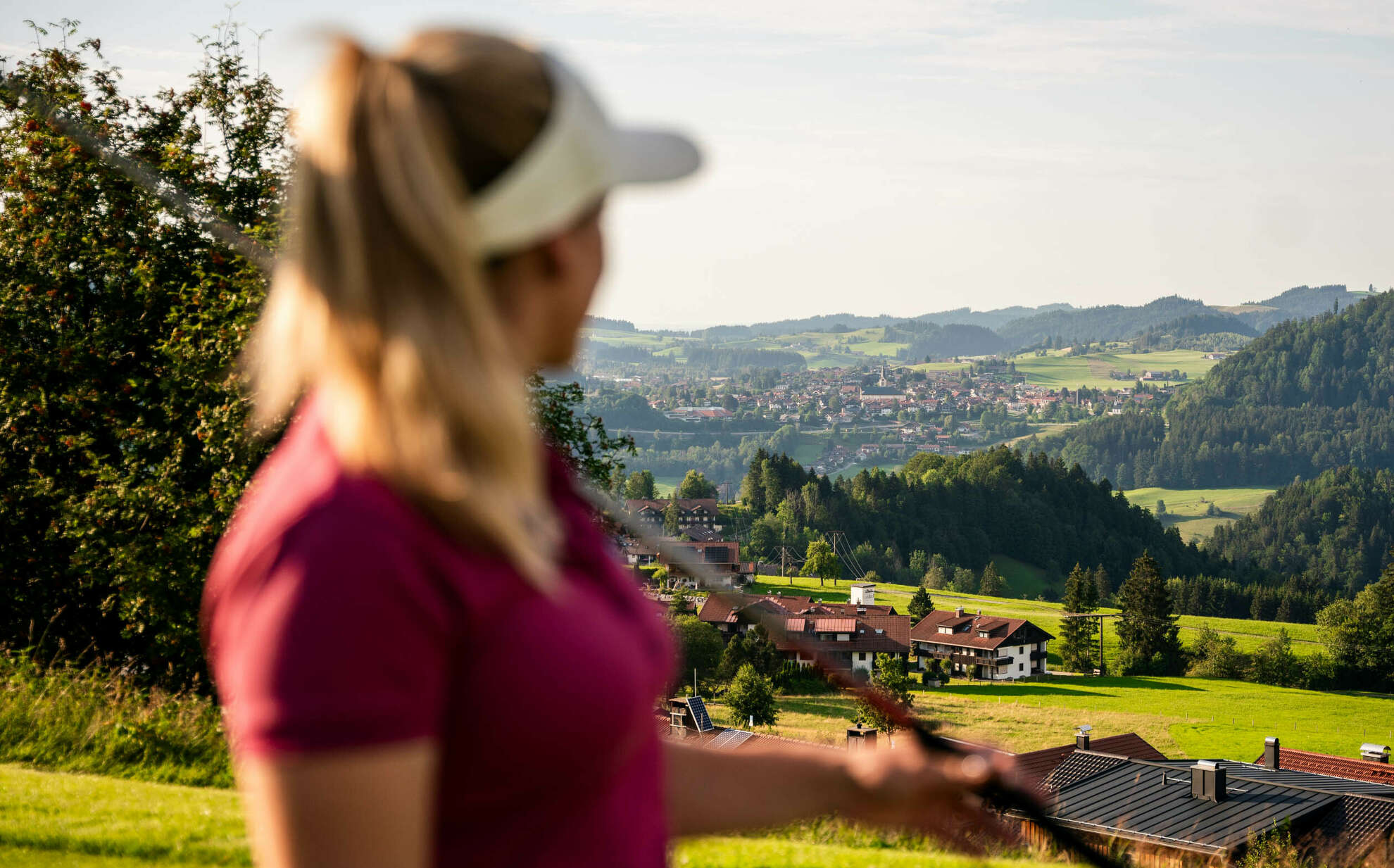 Golferin auf dem Golfplatz Steibis mit Ortsblick auf Oberstaufen