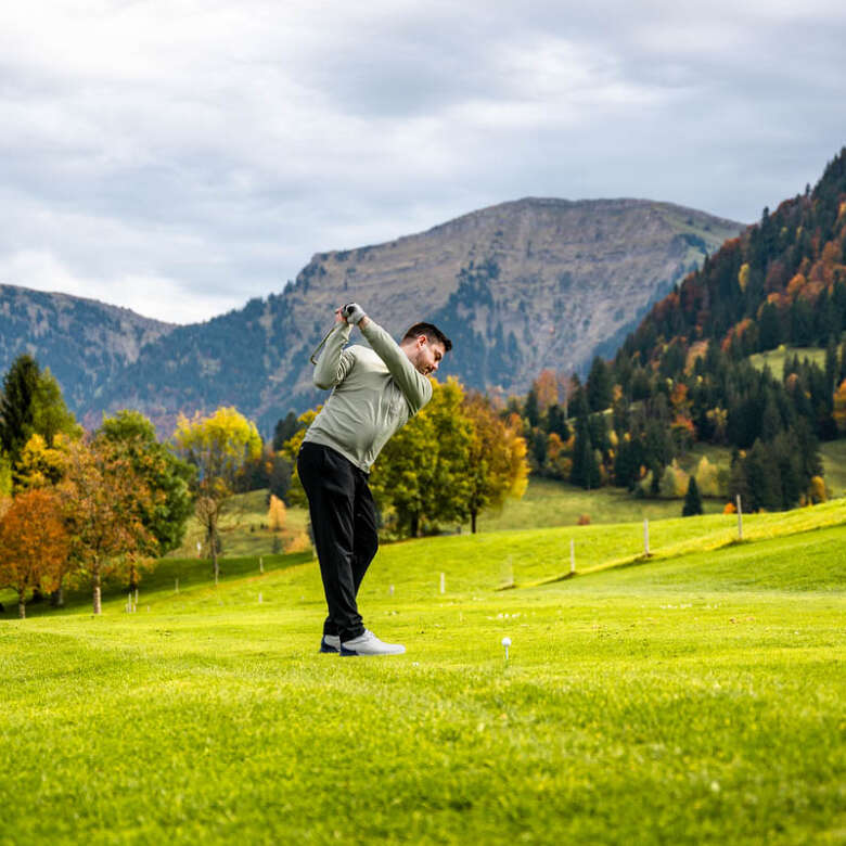 Abschlag beim Golfen in Steibis mit Bergpanorama in herbstlicher Natur.