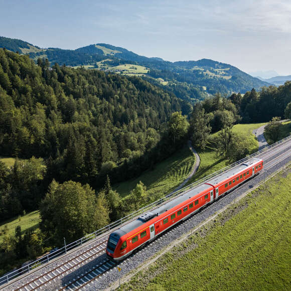 Bahnfahrt durch die grüne Natur von Oberstaufen mit Bergpanorama