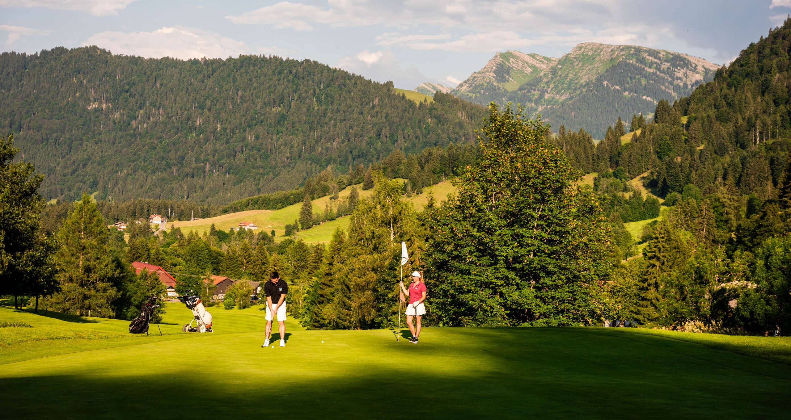 Golfer beim Abschlag in Steibis mit Ausblick auf den Hochgrat