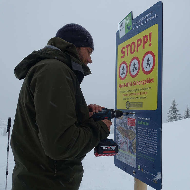 Naturparkranger montieren Informationsmaterial im Naturpark Nagelfluhkette.