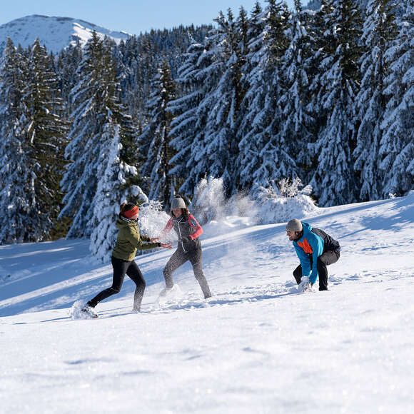 Schneeballschlacht in der verschneiten Winterlandschaft von Oberstaufen