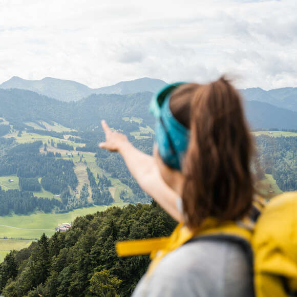 Wanderführerin erklärt auf einer geführten Tour die umliegenden Gipfel der Nagelfluhkette