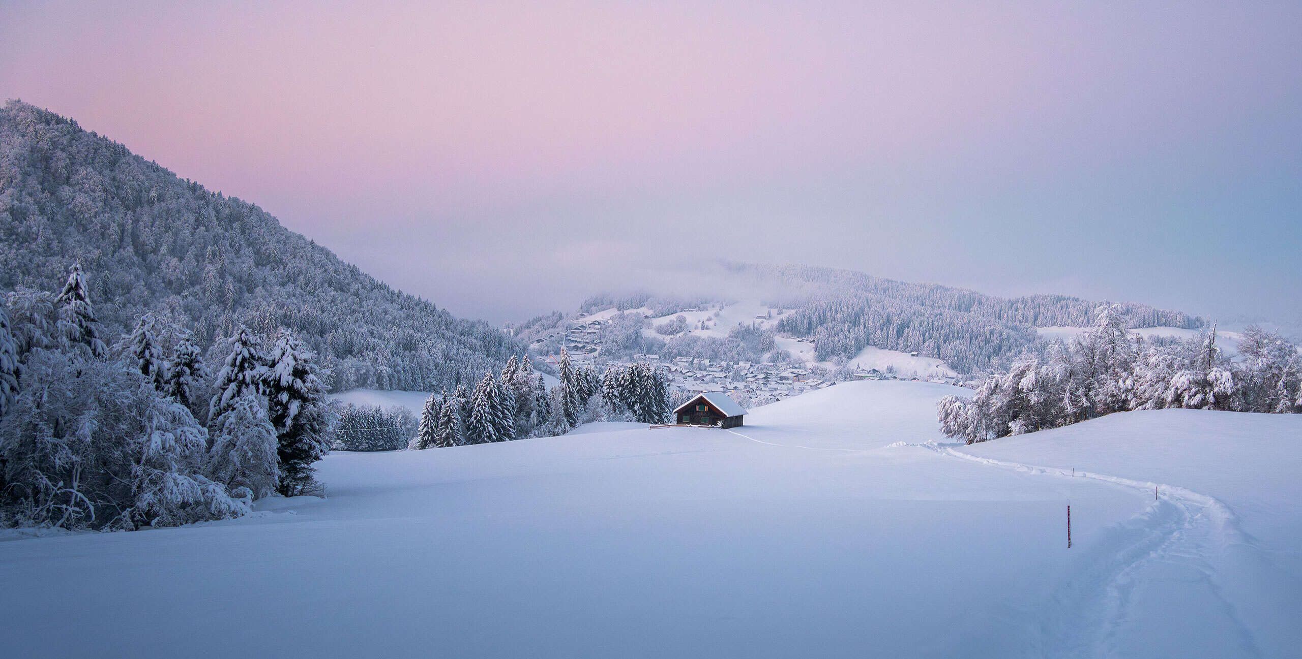 Blaue Stunden einem kalten Wintertag inOberstaufen mit Blick auf den Ort und die verschneite Landschaft,.