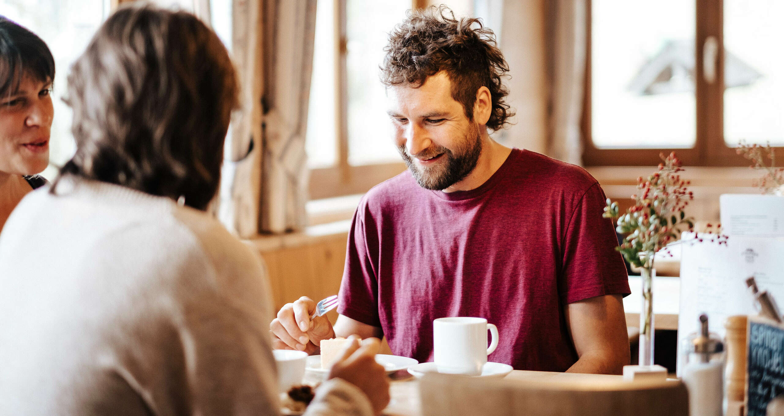 Freunde genießen ein Stück Kuchen und einen Kaffee in einem gemütlichen Cafe