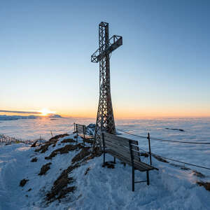 Auf dem Hochgrat Gipfel im Winter über dem Wolkenmeer bei Sonnenuntergang.