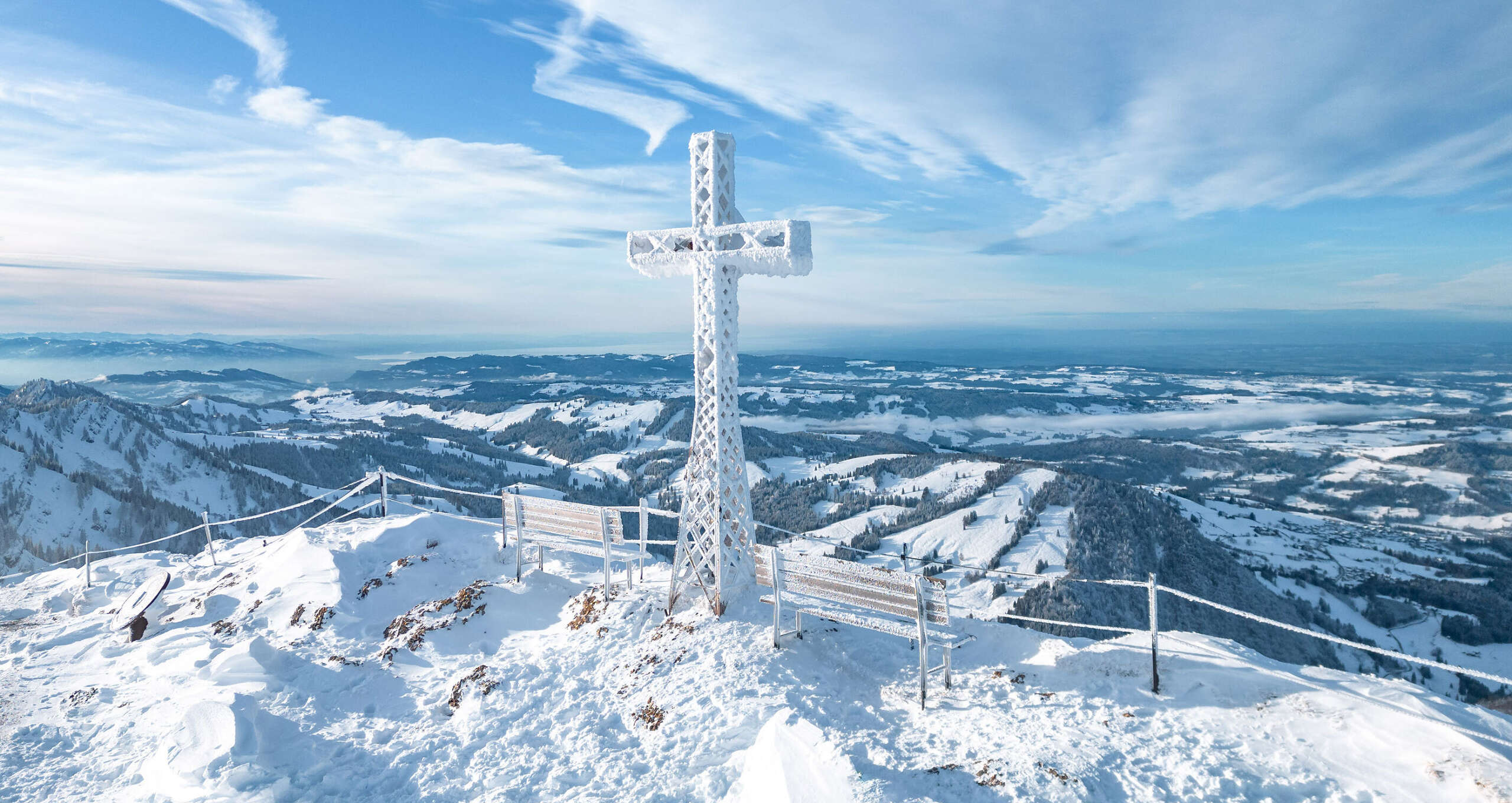 Auf dem verschneiten Hochgrat-Gipfelmit Ausblick auf die Winterlandschaft um Oberstaufen.