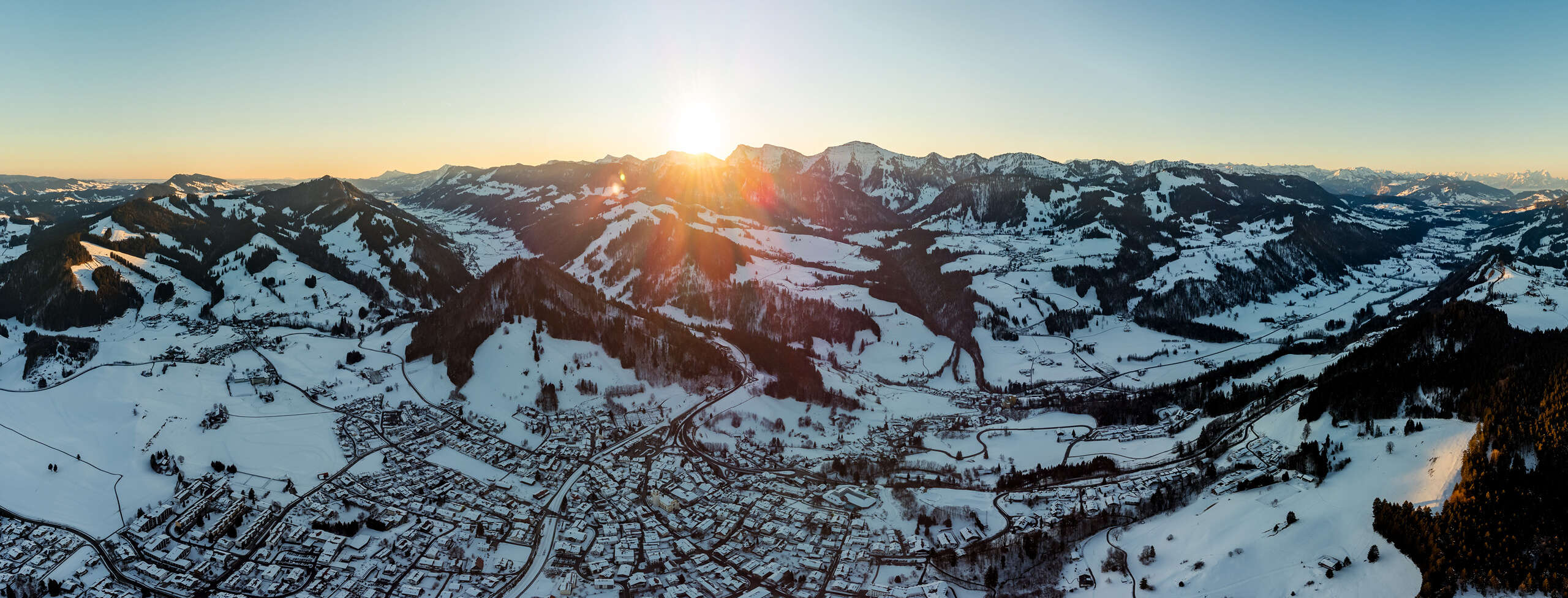 Panoramablick aus der Luft auf Oberstaufen und die umliegenden Berge im Winter