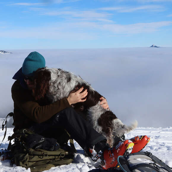 Ranger mit Hund unterwegs im Naturpark Nagelfluhkette im Winter