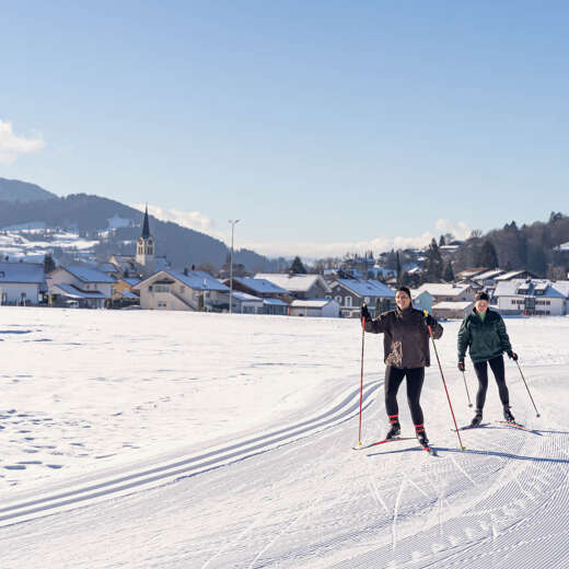 Langlaufen auf der Kalzhofer Loipe in der Wintersonne mit Blick auf Oberstaufen