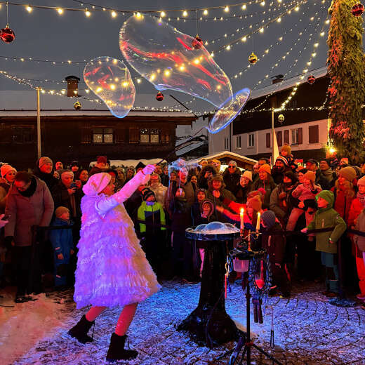 Seifenblasenshow auf dem beleuchteten Marienplatz während des Winterzaubers in Oberstaufen.