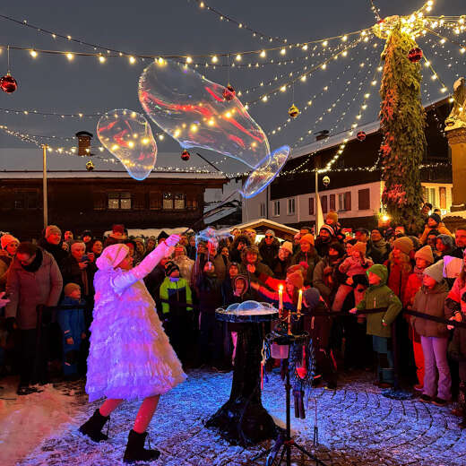 Seifenblasenshow auf dem beleuchteten Marienplatz während des Winterzaubers in Oberstaufen.