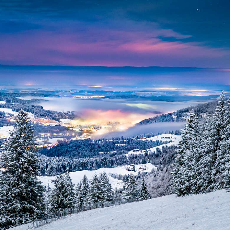 Die Abenddämmerung lässt den Winterhimmel über Oberstaufen aufleuchten.