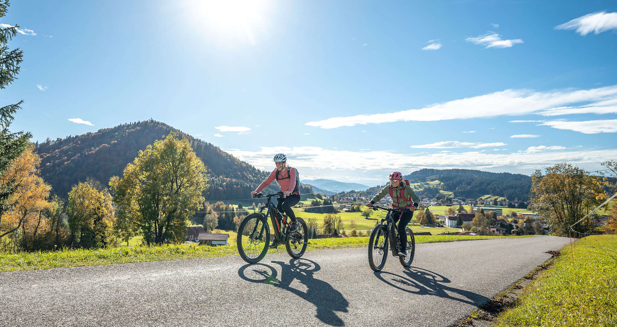 Radler auf dem Hompessenweg mit Ausblick auf Oberstaufen