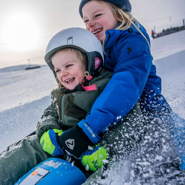 Kinder beim Rodeln im Schnee in Oberstaufen