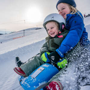 Kinder beim Rodeln im Schnee in Oberstaufen