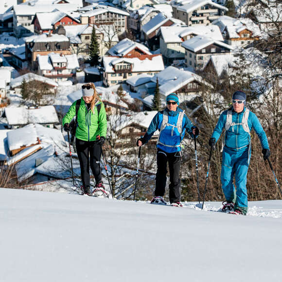 Schneeschuhwandern am Kapf mit Ortsansicht von Oberstaufen