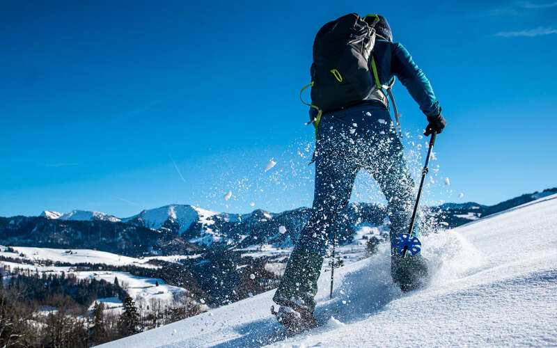 Schneeschuhwanderung mit Hochgratblick an einem sonnigen Wintertag.