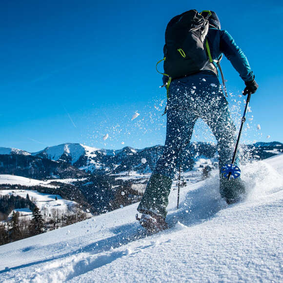 Schneeschuhwanderung mit Hochgratblick an einem sonnigen Wintertag.