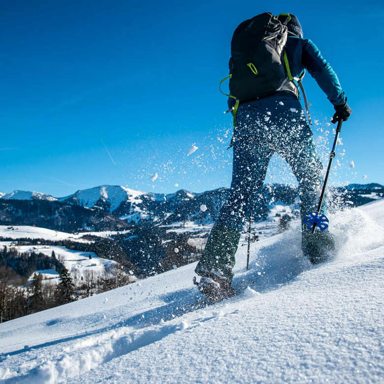 Schneeschuhwanderung mit Hochgratblick an einem sonnigen Wintertag.