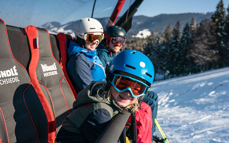 Familie beim Skifahren an der Hochsiedel-Sesselbahn im Hündle-Skigebiet.