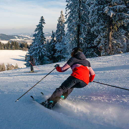 Skifahren auf der Talabfahrt der Skiarena Steibis mit Weitblick auf Oberstaufen