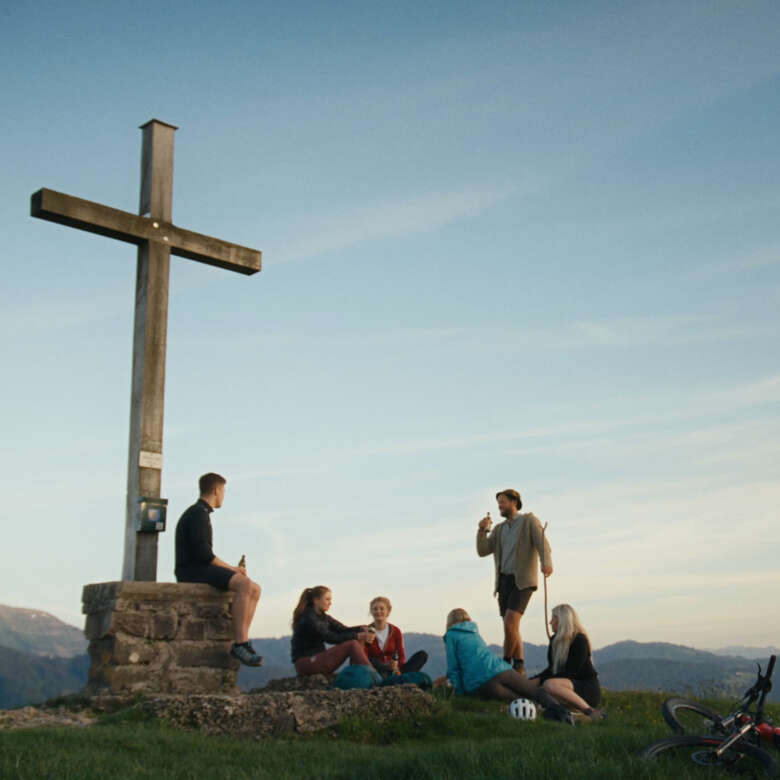 Menschen treffen sich an einem Gipfel im Allgäu, um den Sonnenuntergang zu genießen