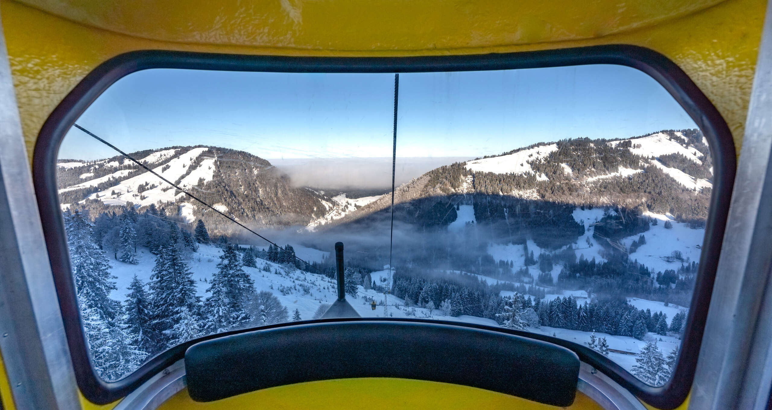 Auffahrt mit der Hochgratbahn mit Blick auf die verschneite Berglandschaft.