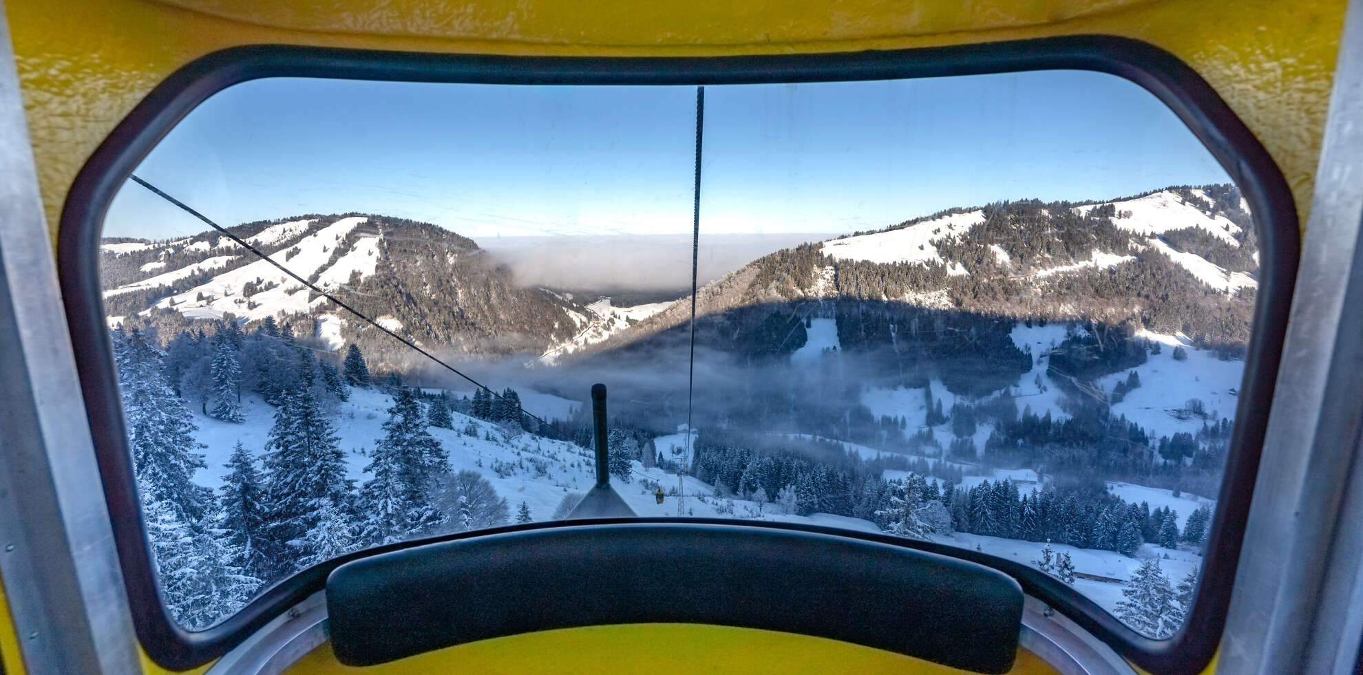 Auffahrt mit der Hochgratbahn mit Blick auf die verschneite Berglandschaft.