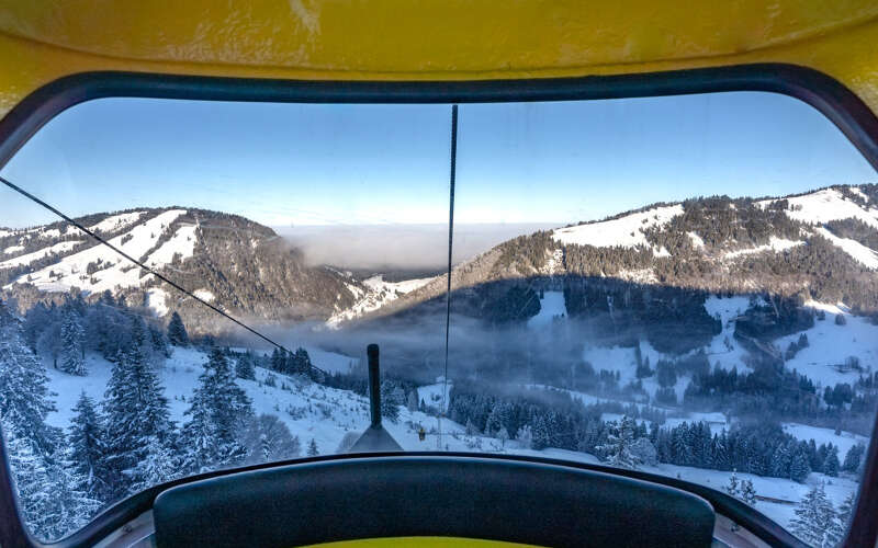 Ausblick aus der Gondle der Hochgratbahn auf die verschneiten Berge von Oberstaufen