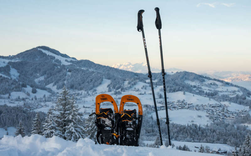 Schneeschuhe auf dem Hündlegipfel mit Weitblick auf den verschneiten Ortsteil Steibis und das weiße Bergpanorama.