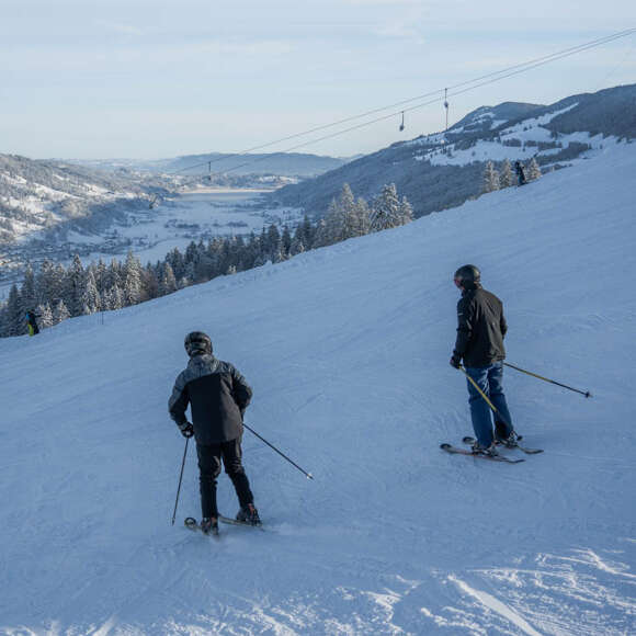 Skifahren auf den Pisten am Hündle mit Weitblick auf das verschneite Konstanzer Tal.