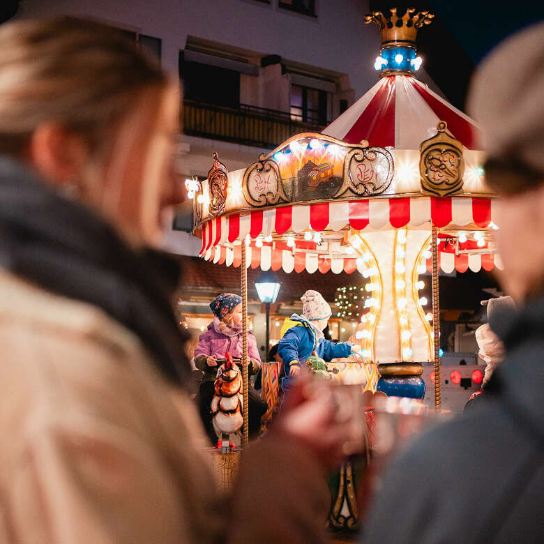 Beleuchtetes nostalgisches Karrusell für Kinder beim Winterzauber Oberstaufen