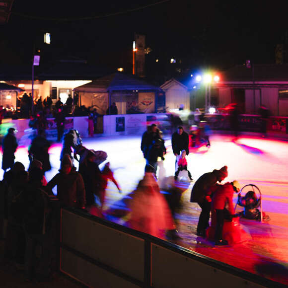 Beleuchteter Eisplatz im Oberstaufen PARK bei Nacht.