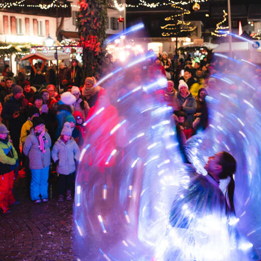 Auftritt der Glow Wings auf dem beleuchteten Marienplatz während des Oberstaufener Winterzaubers